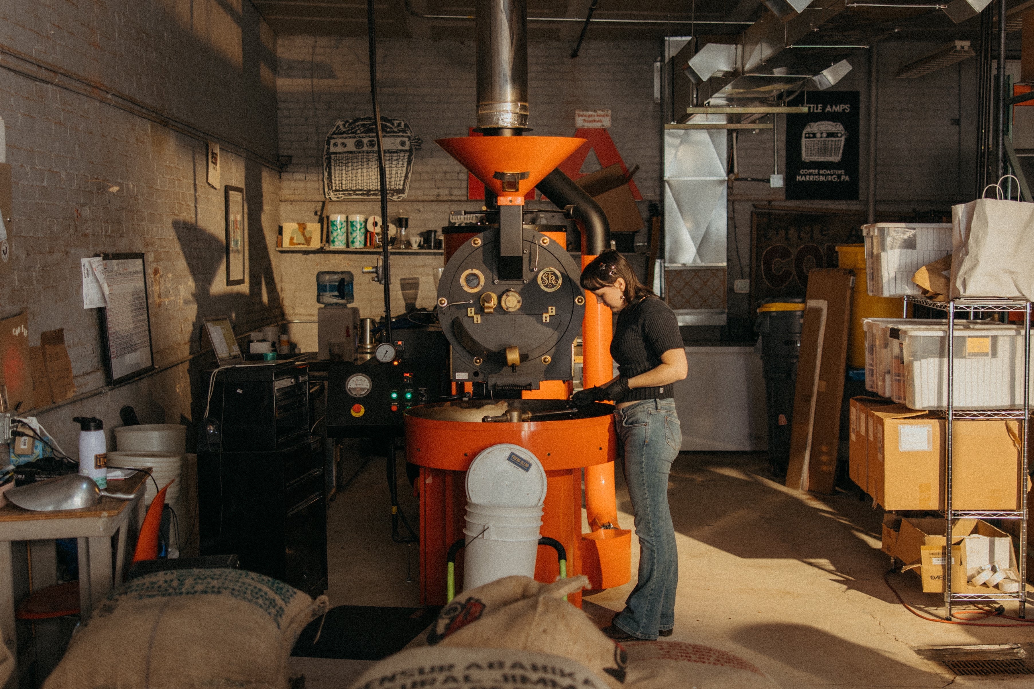 Person working with an orange coffee roaster